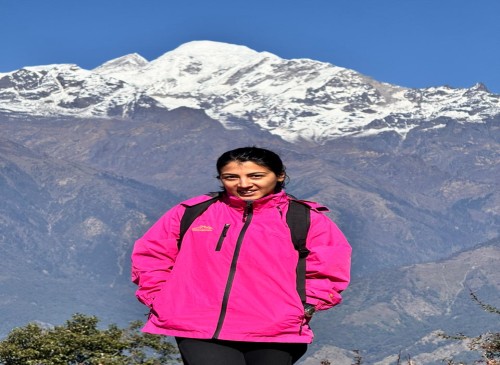 “Snow-covered Buddha Himal peak rising behind rugged lower hills under a clear blue sky.
